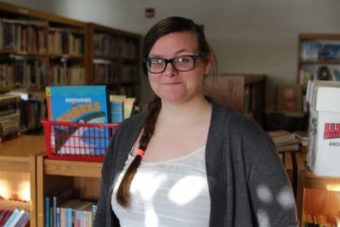 Jocelyn McKinnon-Crowley is the second AmeriCorps VISTA to work on the Kake Library project, after VISTA Lindsey Bennett helped re-open the library last year. Her job this year is to launch programming, coordinate volunteers, and further organize the collection. (Photo by Emily Kwong/KCAW)