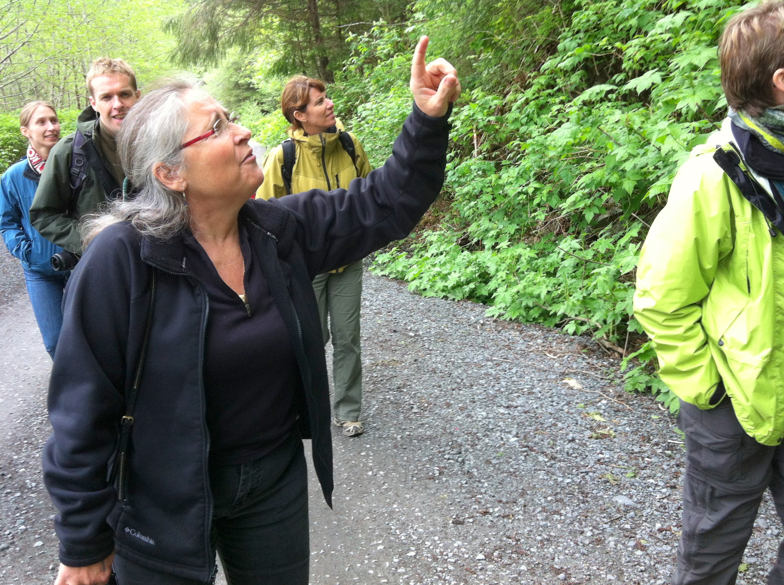 Sitka resident and Tlingit weaver Teri Rofkar takes staff from the National Museum of the American Indian up Blue Lake Road last year. The group was in town for field study, learning about the origins of many of the objects they keep track of in Washington, D.C. Rofkar passed away Friday, Dec. 2, 2016. (Photo by Ed Ronco/KCAW )