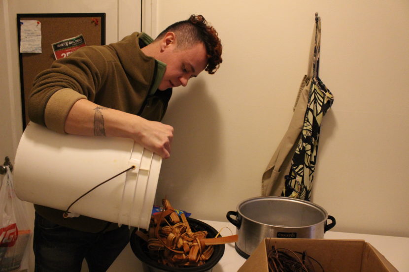 Ricky Tagaban prepares yellow cedar strips to later weave into warp. (Photo by Elizabeth Jenkins/Alaska's Energy Desk)