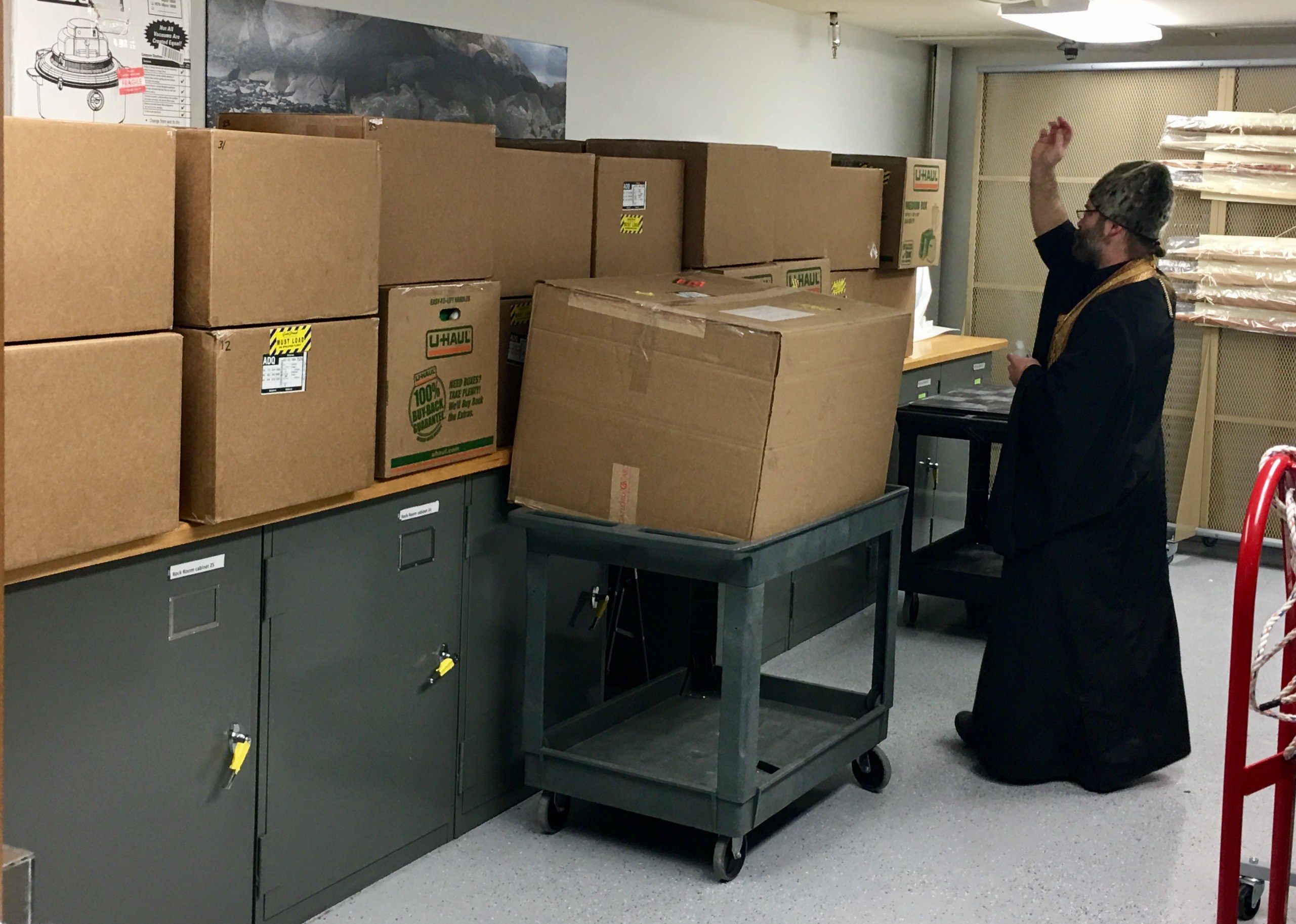 Father Innocent Dresdow performs service on the remains in the room where they’re being kept, in a lower level of the Alutiiq Museum. (Photo by April Laktonen Counceller/Alutiiq Museum)