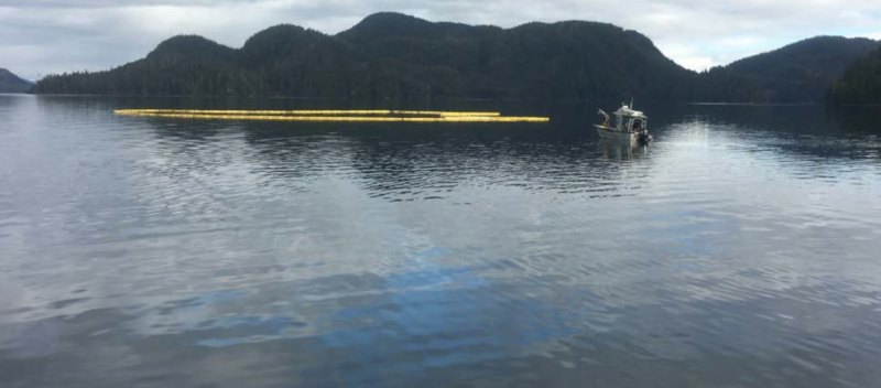 The tugboat Powhatan remains underwater, surrounded by booms to contain the oil spill. (Photo courtesy of SEAPRO)