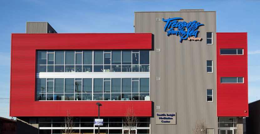 Workers process seafood at a division of Odyssey Foods in Seattle. Sealaska has purchased a majority interest in the company.