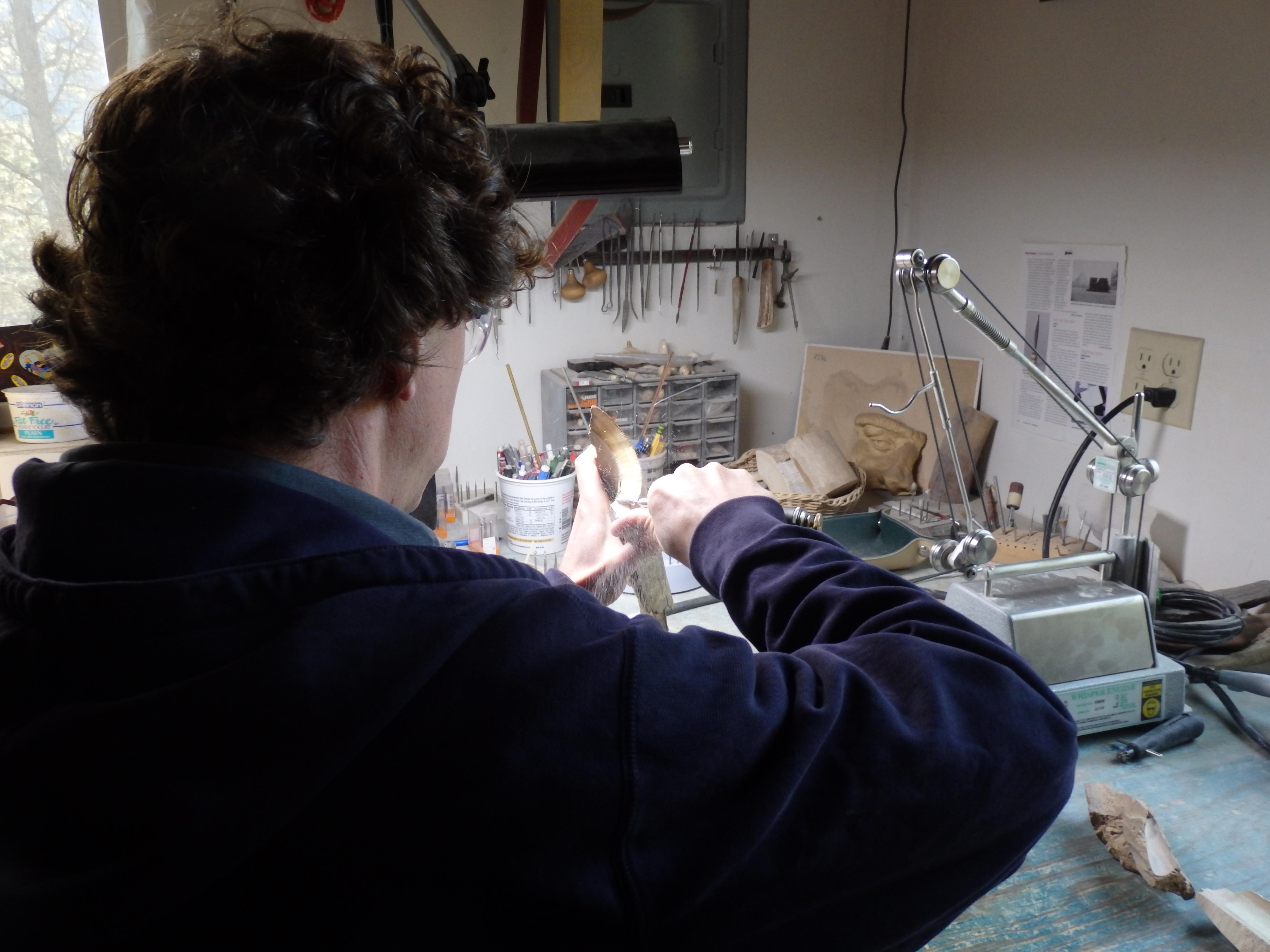 Bruce Schindler carves a piece of mammoth ivory using a dental tool. (Photo by Abbey Collins/KHNS)