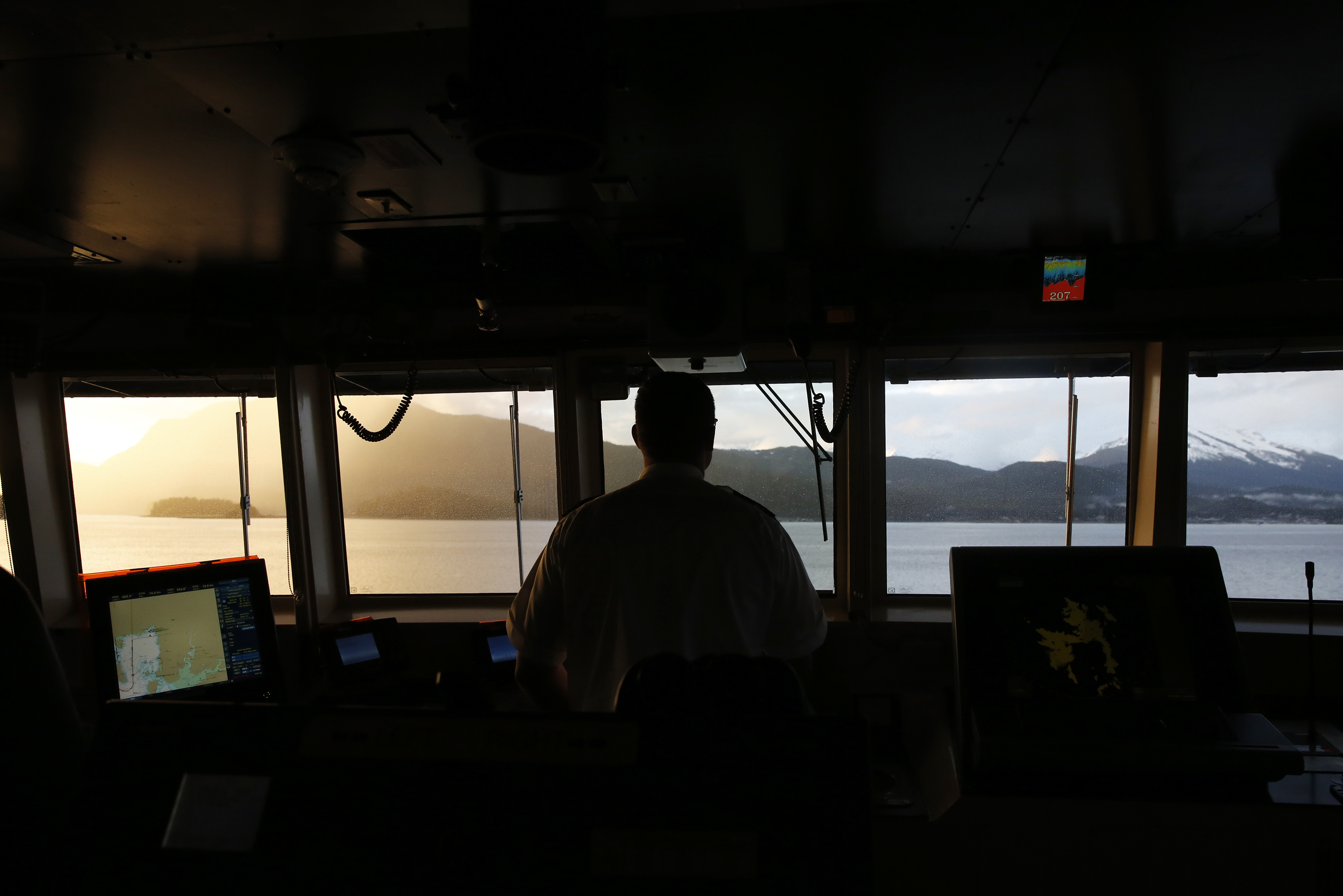 First Mate Aaron Isenhour steers the MV LeConte, a ferry heading from Haines, Alaska, to the state capital, Juneau. (Photo by Elissa Nadworny/NPR)