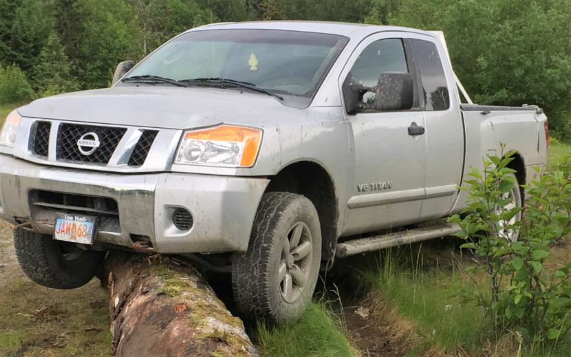 A man police say stole and abandoned about eight vehicles in the past week left this truck high-centered on a large log. Another vehicle was burned. (Photo courtesy Wrangell Police Department)