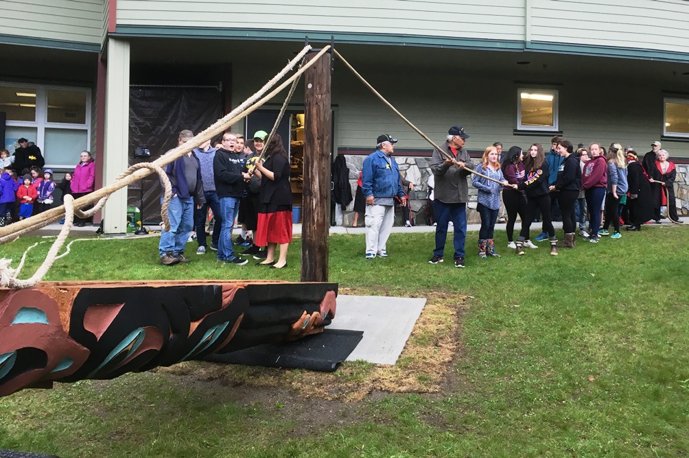 Schoenbar Middle School students and visitors prepare to raise the Pathfinder totem pole. (Photo by Leila Kheiry/KRBD)