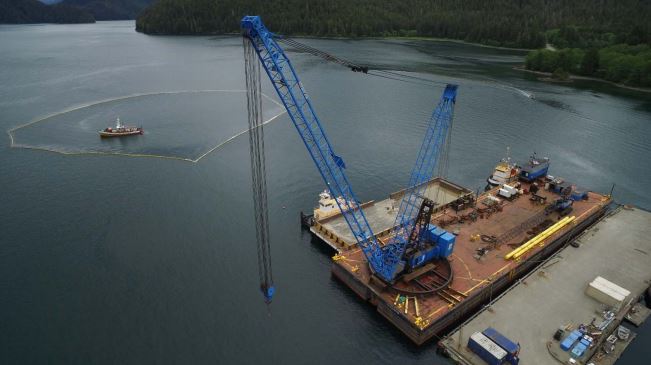 The barge Salvation, the KP-2 deck barge, and two tugs tied up at Samson's dock. The Powhatan tug remains underwater, surrounded by containment boom. The owner plans to raise the tugboat on Thursday, June 8. (Photo courtesy Samson Tug & Barge)