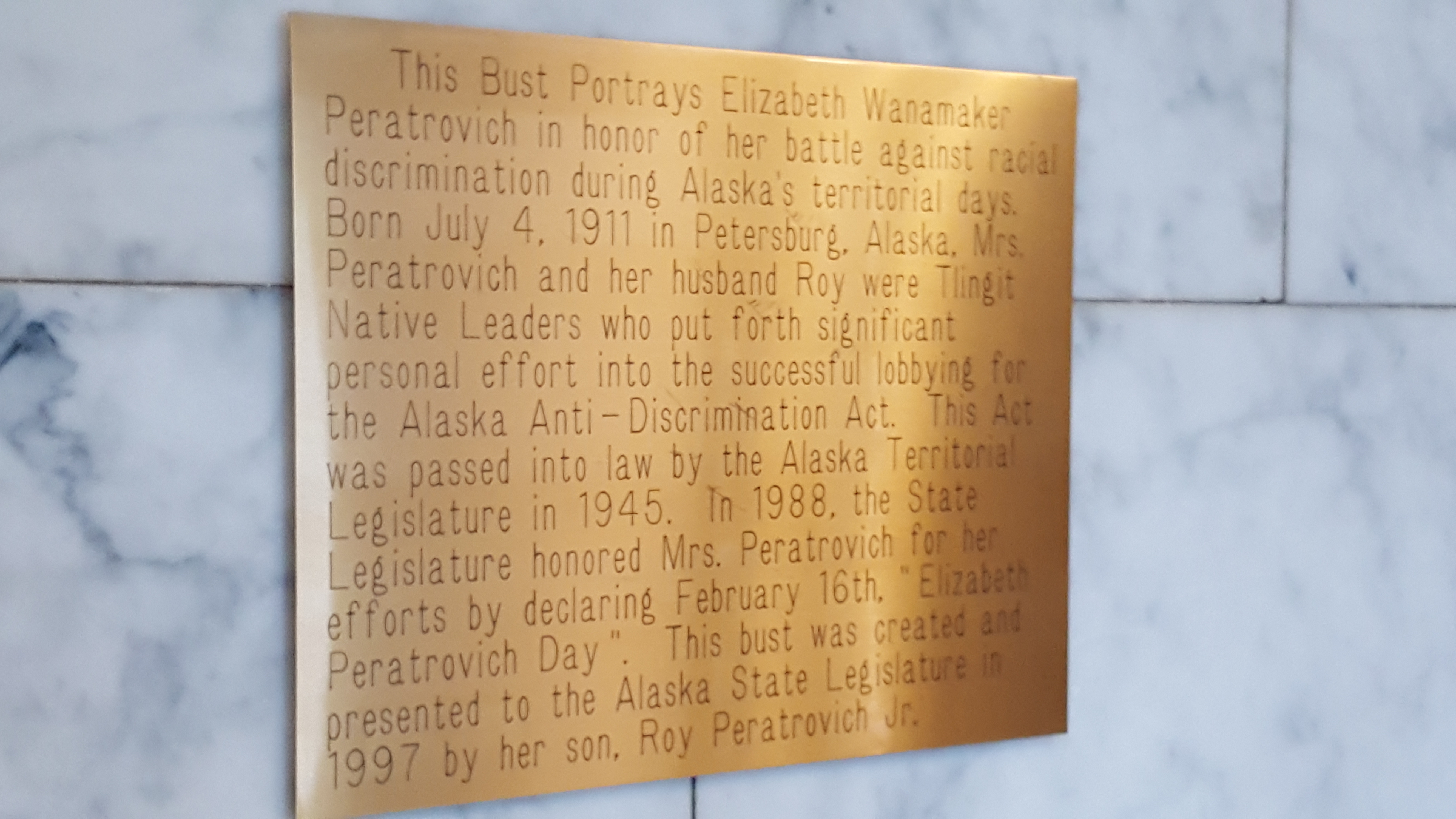 A plaque explains the importance of Elizabeth Peratrovich and the Anti-Discrimination Act of 1945 above a bust of the Alaska Native civil rights leader in the Alaska Capitol in downtown Juneau. (Photo by Tripp J Crouse/KTOO)