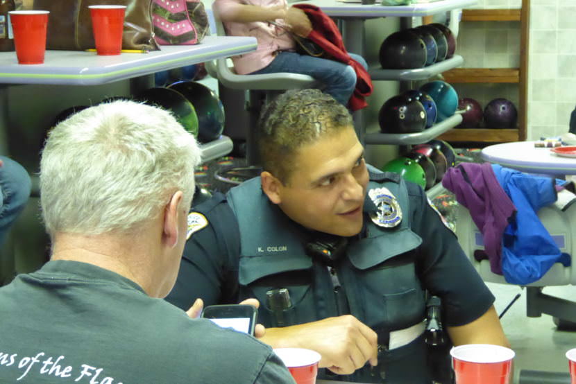 Juneau police Officer Ken Colon watches the Street vs. the Beat game from his seat at Taku Lanes on Saturday, July 15, 2017.