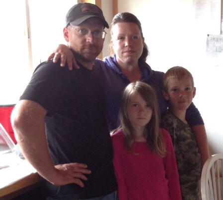 Travis Finkenbinder stands with his wife Samantha, daughter Alyssa and son Taylor in early June of 2014. Finkenbinder later suffered severe head trauma.