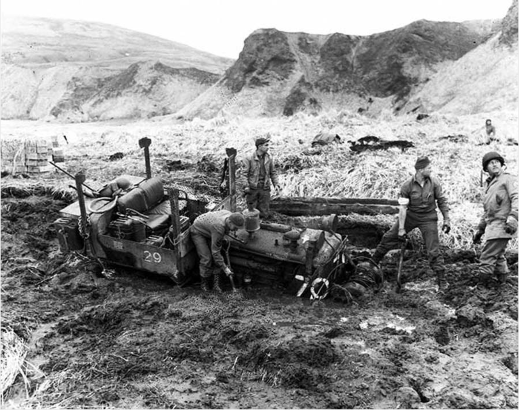 American soldiers dig a tractor from the mud. (Alaska State Library, U.S. Army Signal Corps Photograph Collection, ASL-P175-050)