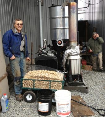 Wes Tyler, left, stands by a new wood gasifier at Icy Straits Lumber in Hoonah. John Hillman of the Hoonah Indian Association is on the right
