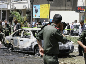 Syrian government security officers after a blast in the Marjeh district of Damascus on Tuesday. Louai Beshara/AFP/Getty Images