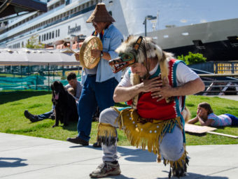 John Smith the 3rd kneels during a dance. (Photo by Heather Bryant/KTOO)