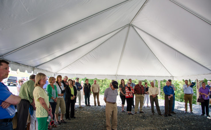 A crowd of approximately 50 people made the journey to the end of the road for the ribbon-cutting. Concerned about afternoon rain showers, DOT sent up a large tent for the speakers. It served as a magnet for large black flies.