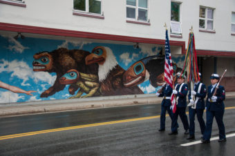 The color guard marches past City Hall