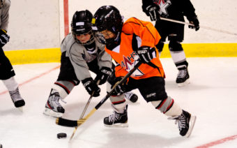 From left, Oliver Stopher and Dylan Sowa battle for a puck while working on a drill at the Rocky Mountain Hockey School.