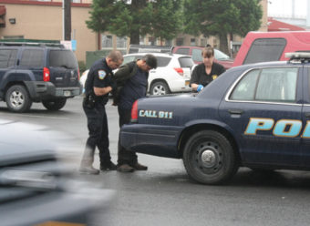 Richard Davis is taken into custody at the Pioneer Bar on Sunday. The 55-year-old Juneau man is skipper of the fishing vessel West Bank. He faces charges of assault and misconduct involving a weapon. (KCAW photo by Ed Ronco)