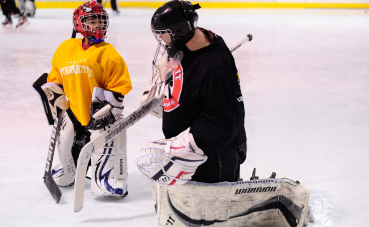 Neal Chapman, right, pulls double duty as a student and teacher as a group of goalies work on their game during a JDIA skills development camp.