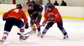 Killer Whales teammates Matt Lilliard (left) and Kathleen Hanson converge on Thane’s Shawn Eisele in front of the Killer Whales net during a second-round Tier B playoff game.