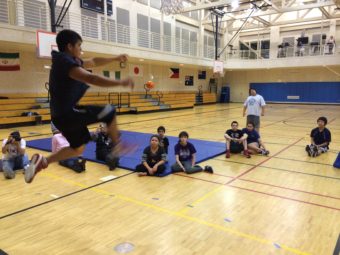 Paul Marks II demonstrates the one foot high kick in preparation for the Native Olympics. (Photo by Scott Burton/KTOO)