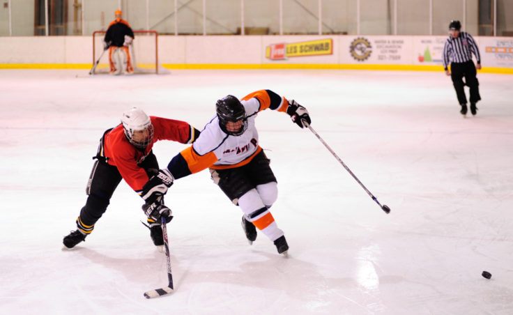 Kensington defenseman Dave Kovach works to impede Island Pub forward Dan Teske’s progress as Teske enters Island Pub’s offensive zone.