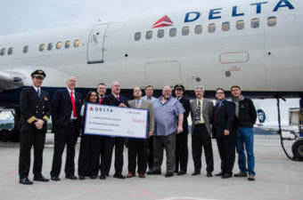 Delta’s Seattle Vice President Mike Medeiros presents a check for $10,000 to the Juneau Community Foundation. (Photo by Heather Bryant/KTOO)