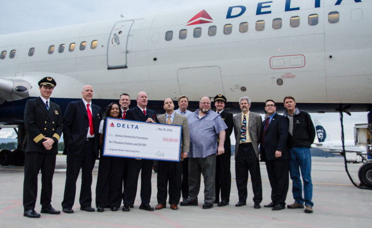 Delta’s Seattle Vice President Mike Medeiros presents a check for $10,000 to the Juneau Community Foundation. (Photo by Heather Bryant/KTOO)