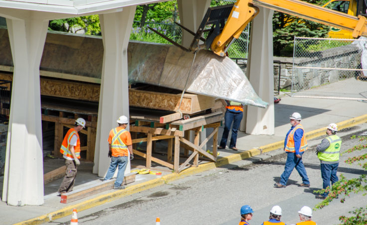 Construction crews hoisted the 45-foot walrus skin umiak up and over the Alaska State Museum with a crane. (Photo by Heather Bryant/KTOO)