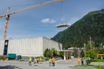 Construction crews hoisted the 45-foot walrus skin umiak up and over the Alaska State Museum with a crane. (Photo by Heather Bryant/KTOO)