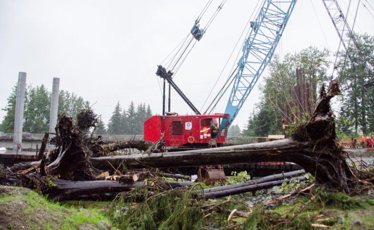 The crane at Brotherhood Bridge removed logs from the river yesterday after a log jam formed at the bridge. (Photo by Heather Bryant/KTOO)
