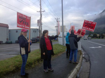 Supporters of Ballot Measure 1 to repeal the state’s current oil tax law, Senate Bill 21, wave signs on Egan Drive at the Juneau-Douglas Bridge, August 19, 2014. (Photo by Casey Kelly/KTOO)