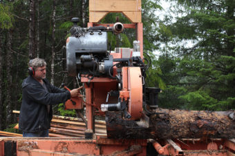 Chris Fry milling a spruce log. (Photo by Elizabeth Jenkins/KFSK)