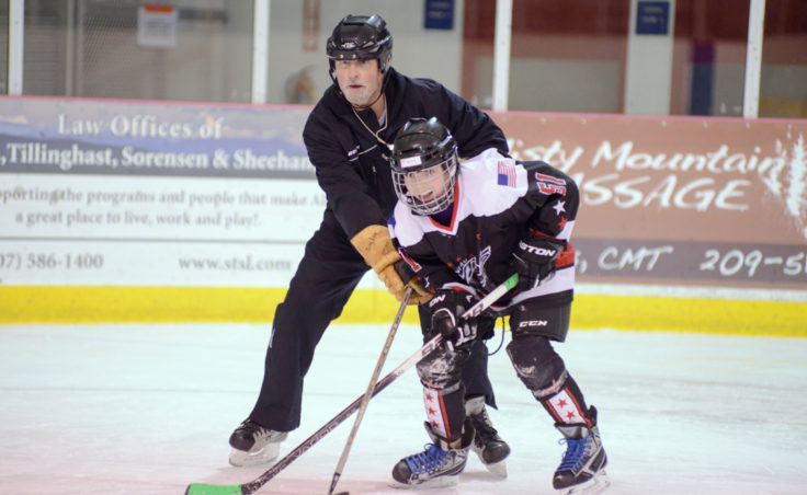 JDIA Coach Mark Kaelke and Kara Hort battle for position during a clinic-ending game Tuesday night at Treadwell Arena.
