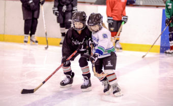 Ema Jessen (left) and Rayanna Wolfenberger lean into each other while trying to maintain their position along the blue.
