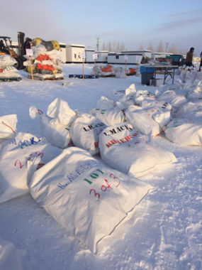 Drop bags are organized by the checkpoint that is written on them before they are packed onto pallets for shipping. (Photo by Emily Schwing KUAC)