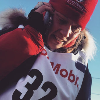 Aliy Zirkle talks briefly with her mom at the Iditarod finish line. She carried a picture of the two of them in a sled bag for 1000 miles because her mother couldn’t be in Nome this year. (Photo by Emily Schwing/APRN)