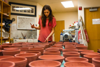 Mercedes Muñoz with the bowls she has just finished glazing for the Empty Bowls fundraiser (Photo by David Purdy/KTOO)