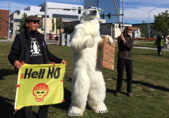 Carl Wassilie, left, stands with protestors against Arctic drilling. The protest took place during the GLACIER conference in Anchorage where President Obama began his Alaska trip. (Photo by Anne Hillman/APRN)