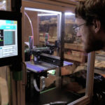 Sam Bornstein looks into the 3D printer at Juneau Makerspace
