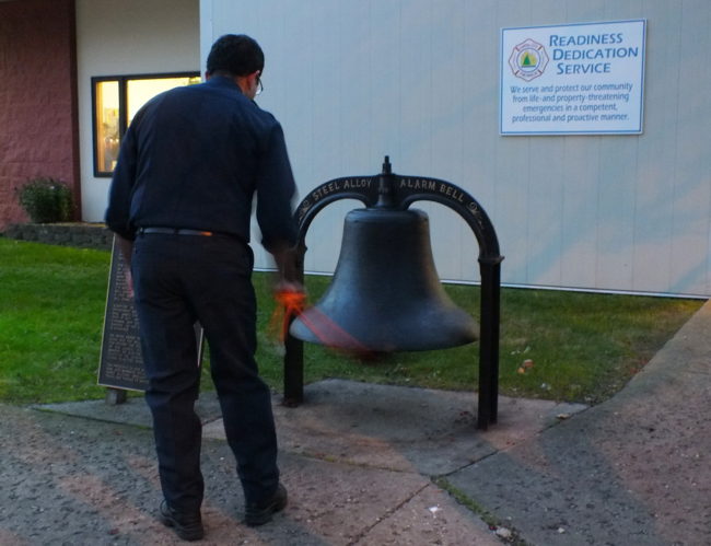 Firefighter Masoud Abdi rings the station bell for the Last Alarm. (Photo by Matt Miller/KTOO)