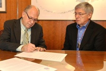 Gov. Bill Walker signs a memorandum of understanding with British Columbia Wednesday as Lt. Gov. Byron Mallott watches. (Photo courtesy governor's office)
