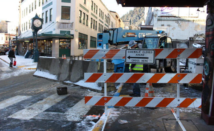 Construction workers move concrete blocks to create a buffer area around the Gastineau Apartments. (Photo by Elizabeth Jenkins/KTOO)