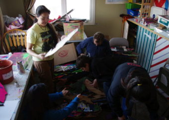 Anna Rae Petla, employee Gregg Marxmiller, and other teens organize the art room at Myspace. (Photo by Molly Dischner/KDLG)