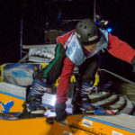 32 - Tosh, grabs his board as he slides down the edge of the box at the Downtown Rail Jam Dec. 19th. (Photo by Mikko Wilson/KTOO)