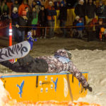 38 - Bethany, performs a belly slide down the box at the Downtown Rail Jam Dec. 19th. (Photo by Mikko Wilson/KTOO)