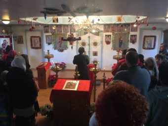Subdeacon Ephim Moonin leading the Orthodox Christmas Eve celebration at Saint Sergius and Herman church in Nanwalek. (Photo by Daysha Eaton/KBBI)