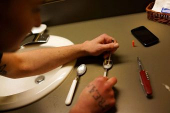 Heroin is prepared to shoot by a man in Vermont in 2014. A New England Journal of Medicine review says those who abuse prescription painkillers are less likely than previously thought to use heroin as well. (Spencer Platt/Getty Images)