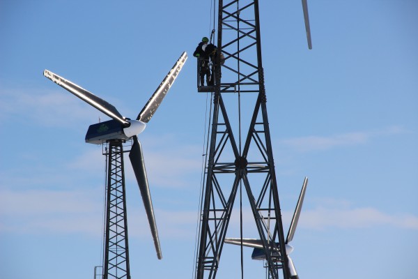 Patrick Boonstra of Intelligent Energy Systems, and Kwigillingok wind tech Benny Daniel check a turbine after a blizzard the night before. (Photo by Rachel Waldholz/APRN)