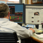 Chris Cummins, a senior portfolio manager at the Alaska Permanent Fund Corp., monitors a variety of economic information at his desk in the corporate headquarters, March 14, 2016. (Photo by Skip Gray/360 North)